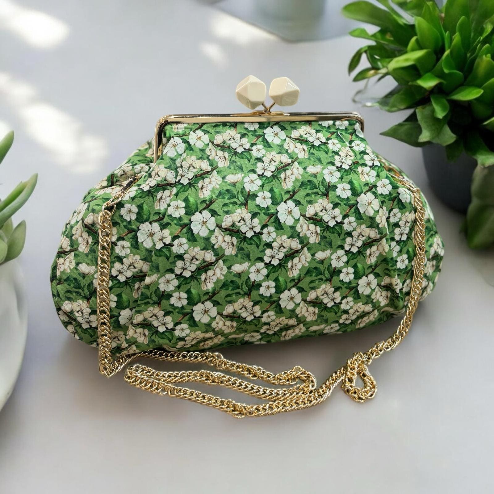 Borsa clutch in tessuto cotone verde con fiori beige e bianchi
