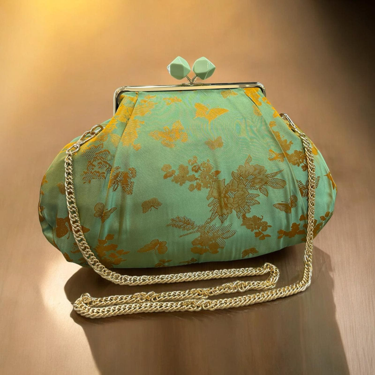 Borsa clutch in tessuto jaquard verde con fiori dorati